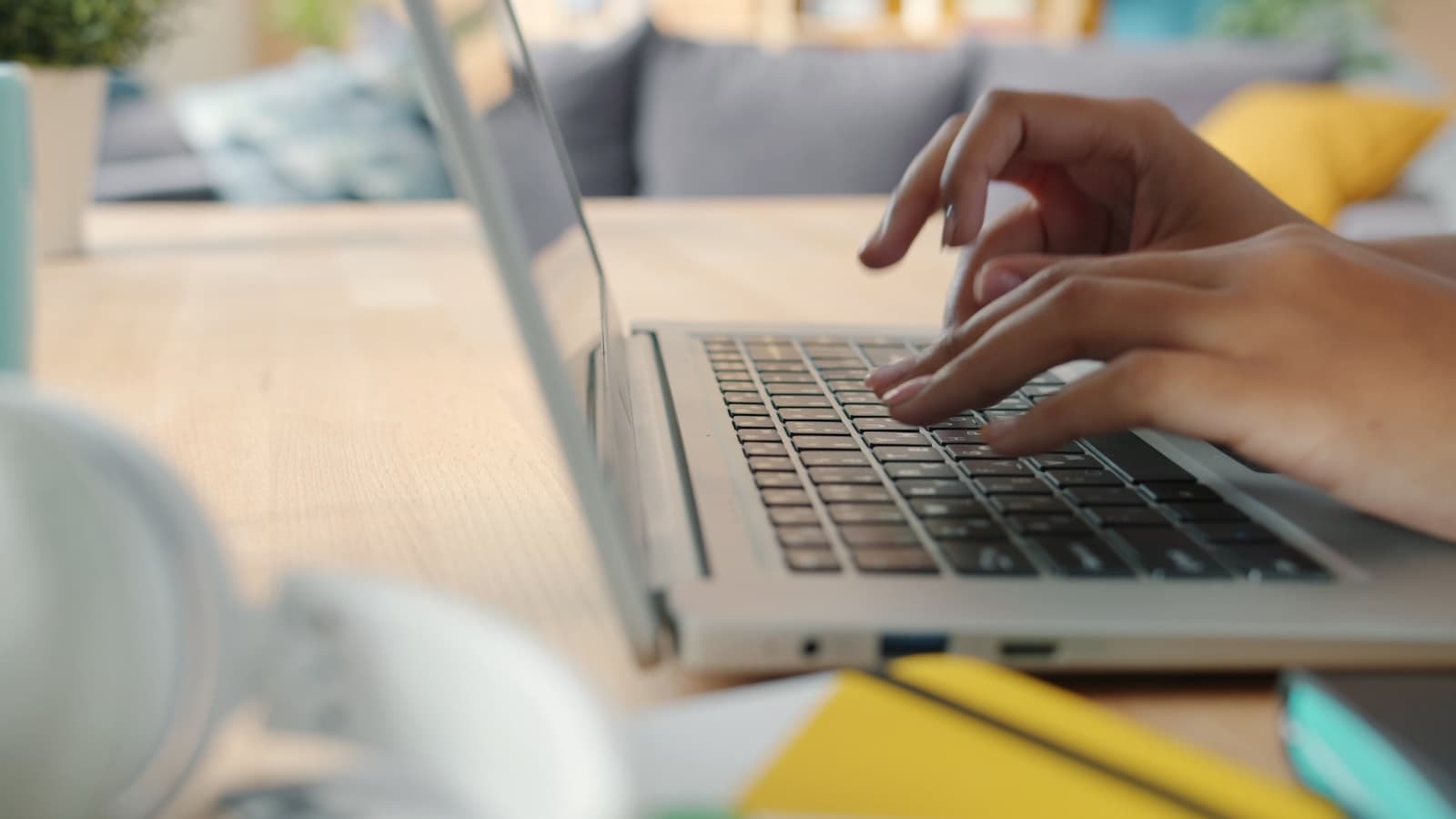 Hands typing on a laptop at a desk